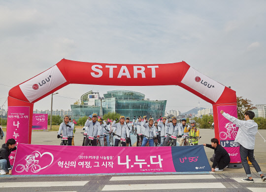 LG유플러스 직원들이 서울 반포 한강공원에서 자전거 라이딩 기부 캠페인을 진행하며 사진을 찍고 있다. LG유플러스 제공